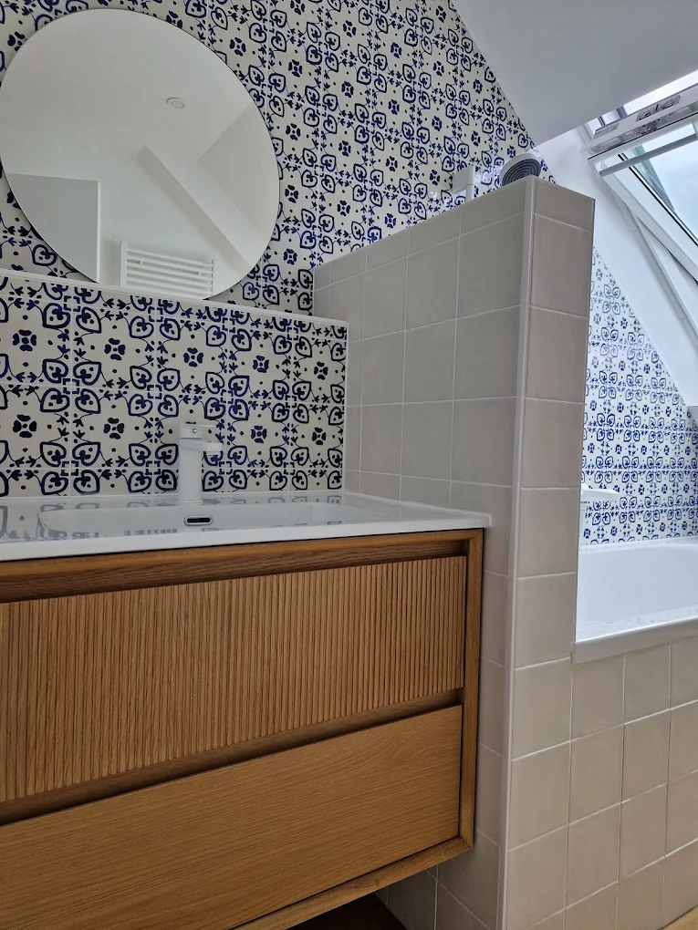 Rénovation salle de bain à Rezé — meuble vasque cannelé bois, miroir rond et faïence carreaux de ciment bleu