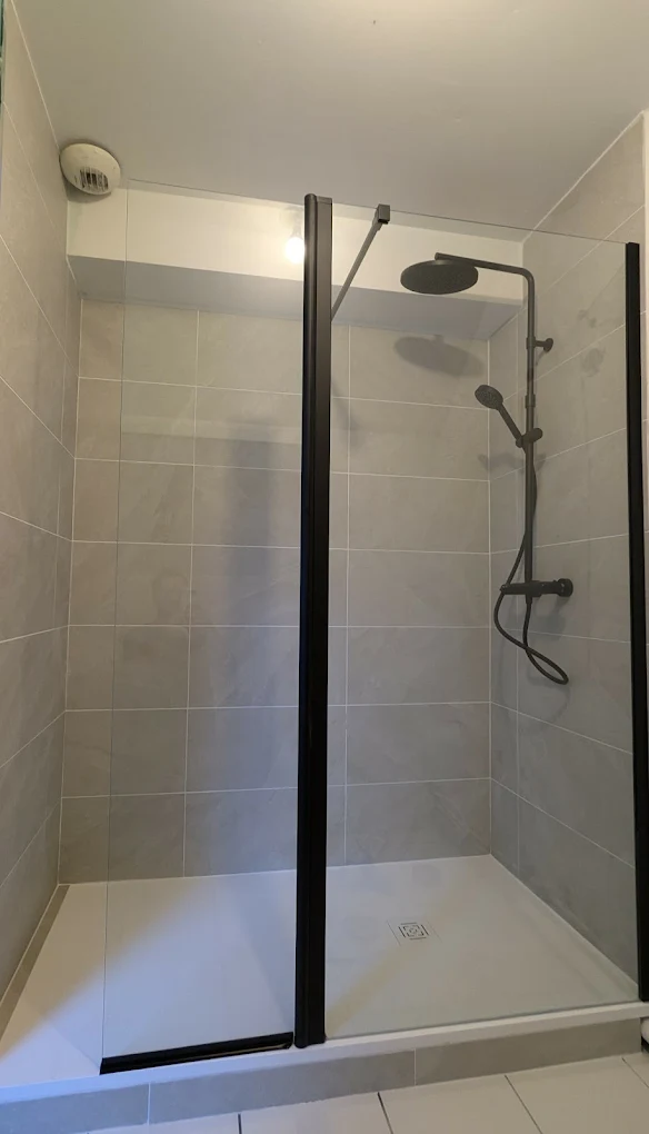 Installation d'une douche à Saint-Sébastien-sur-Loire — faïence grise, paroi vitrée à cadre noir et colonne de douche